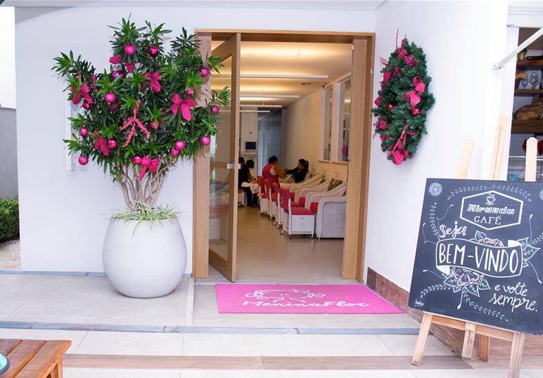 Entrada decorada do salão com lousa de boas-vindas e cantinho do café