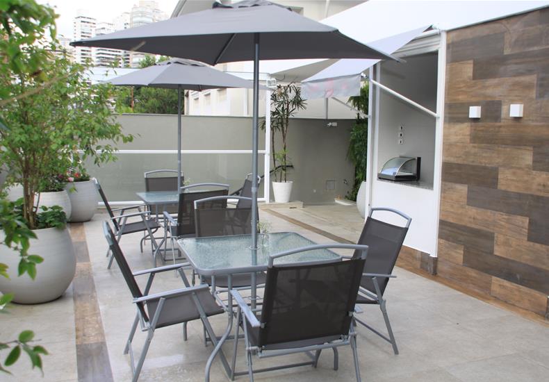 Terraço com mesas e guarda-sóis do Menina Flor Estética